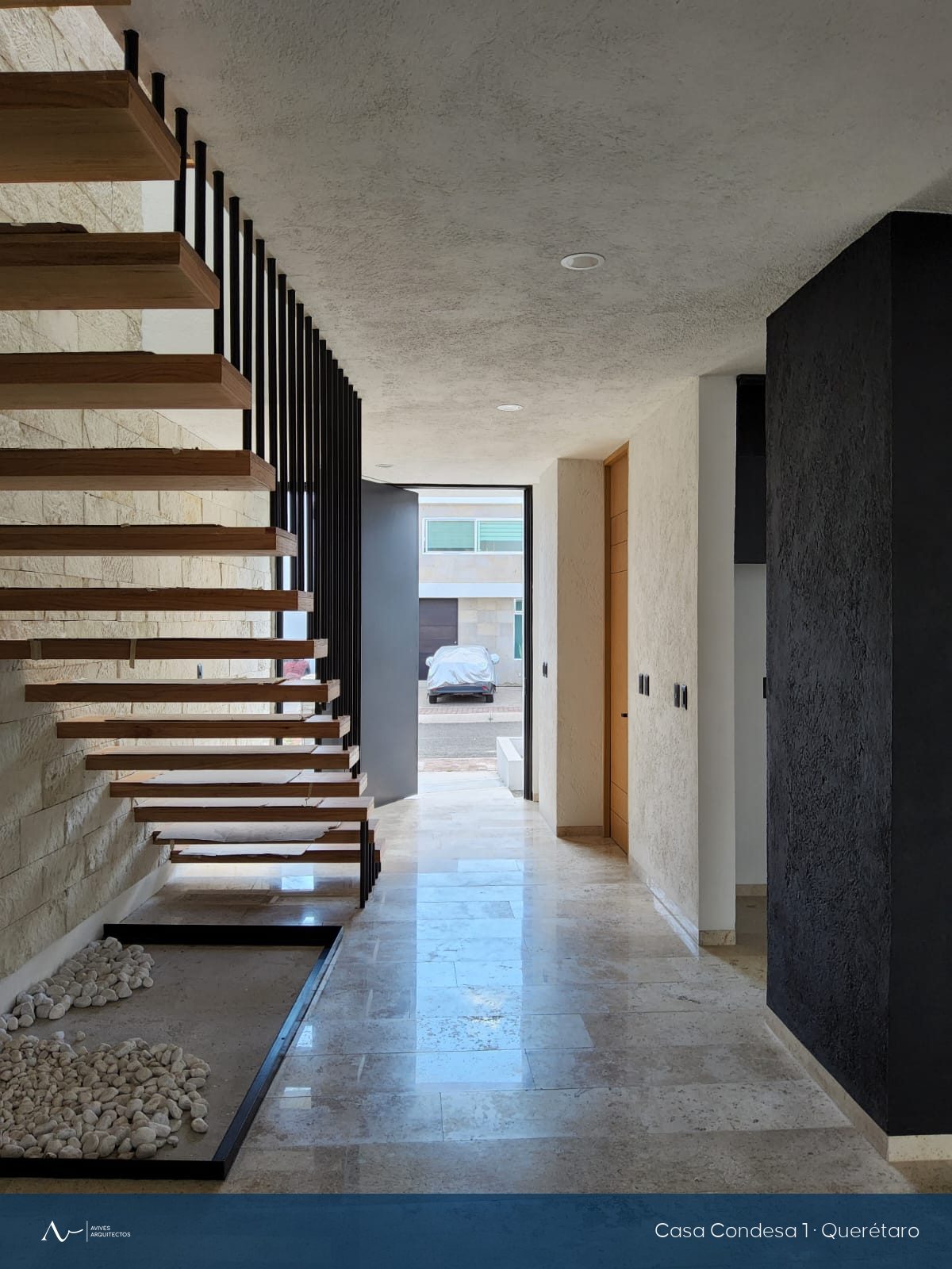 Escalera flotante de madera sobre muro de piedra natural, ya terminada