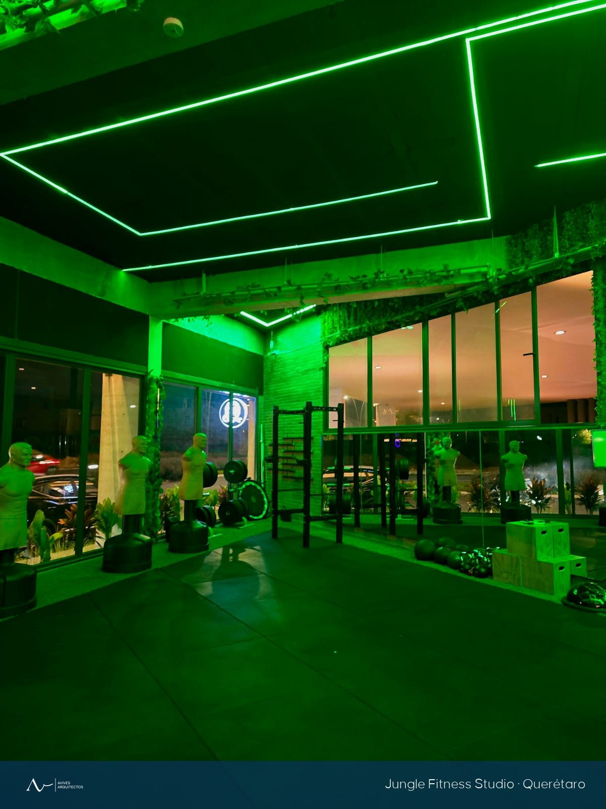 La misma sala del gimnasio de noche, con la iluminación lineal verde encendida