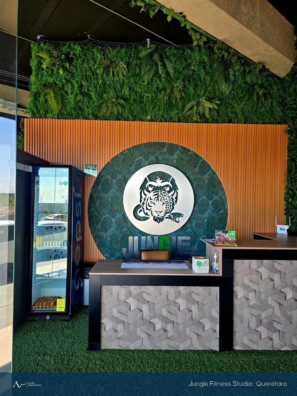 Área de recepción y muro vegetal del gimnasio Jungle en Querétaro